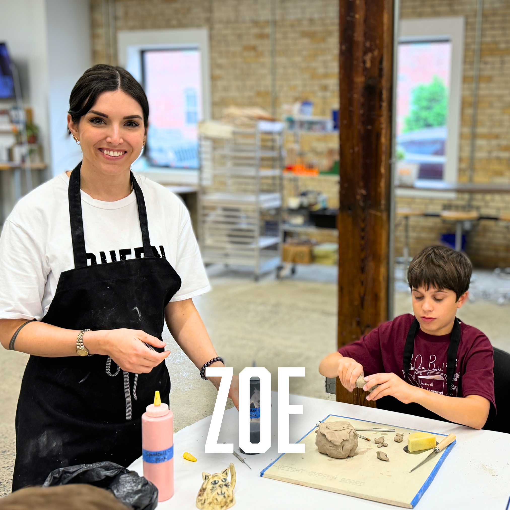 Hub Educator, Zoe, helps a student with his pottery project.