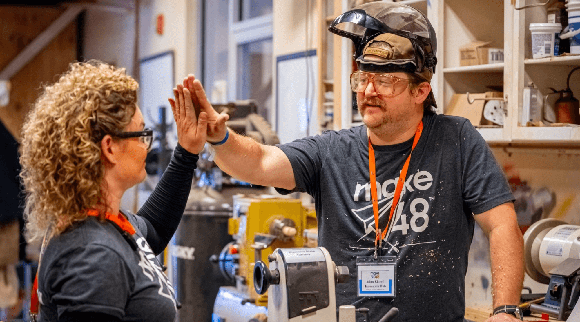 Make48 Participants high five after completing a woodworking project.