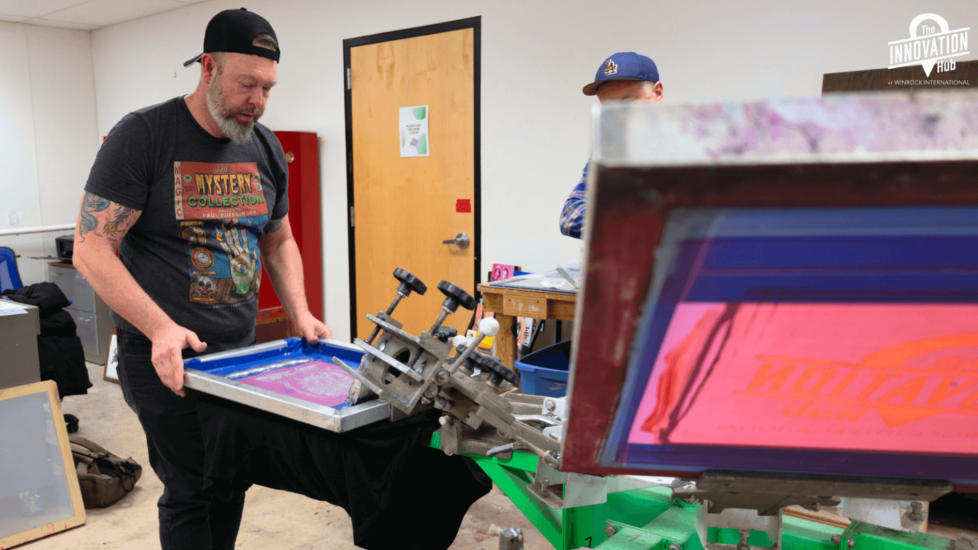 Man is screen printing a t-shirt.