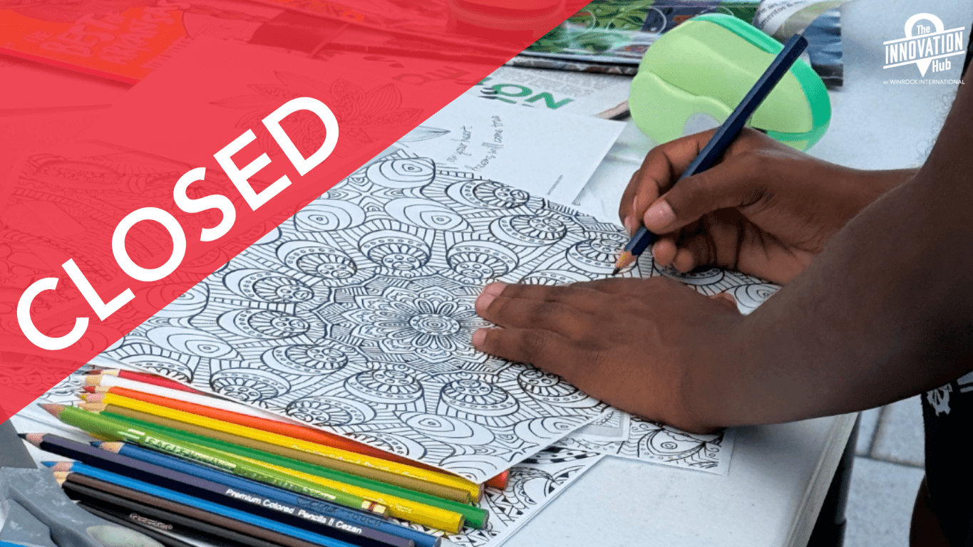 A child uses colored pencils to color in the details of a mandala design for button-making activities.