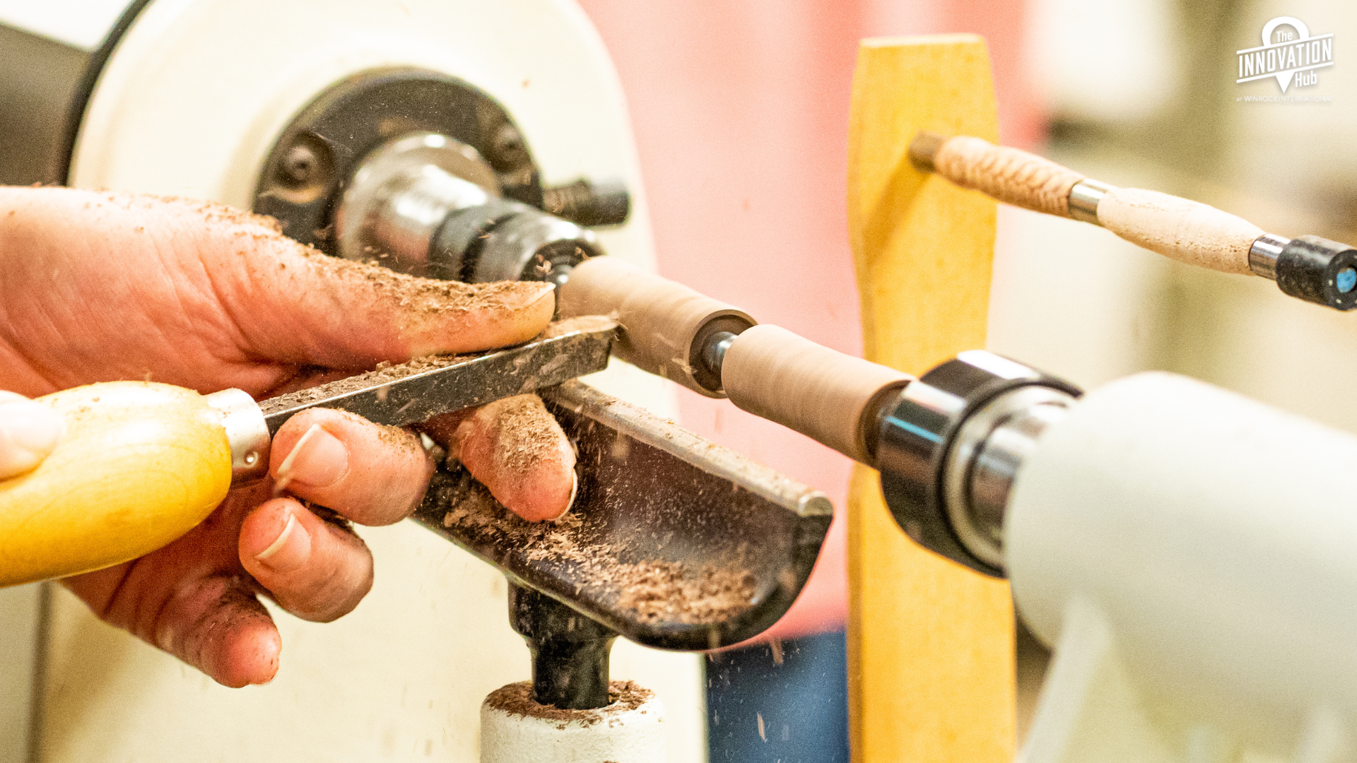 Someone using a pottery wheel and they are shaping a vessel